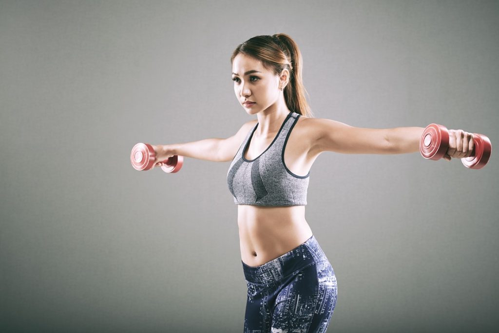 woman holding dumbbell to the side