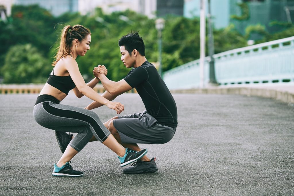 couple performing pistol squat calisthenics exercise