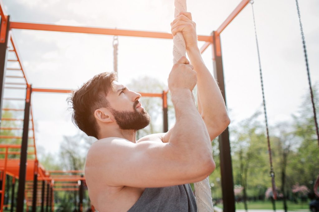 man climbing rope outdoors