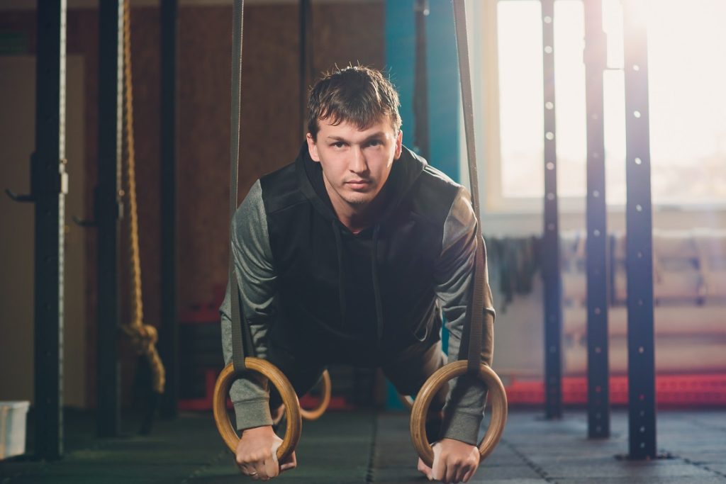 man doing calisthenics workout on gymnastic rings