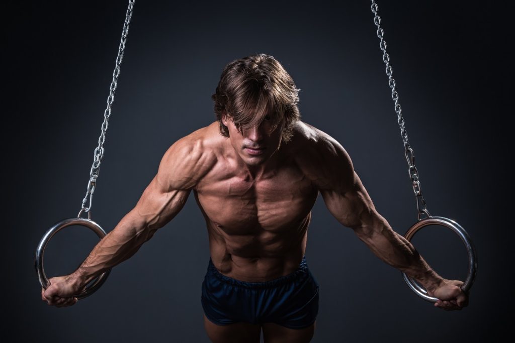 man doing chest flyes on gymnastic rings